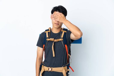 Dağcı Çinli adam, beyaz arka planda tek başına, gözlerini elleriyle kapatıyor. Bir şey görmek istemiyorum.