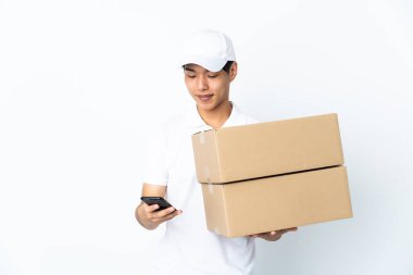 Çinli adam beyaz arka planda izole edildi ve cep telefonuyla bir mesaj gönderiyor.