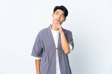 Beyaz arka planda yalnız yaşayan genç Çinli adamın şüpheleri var.