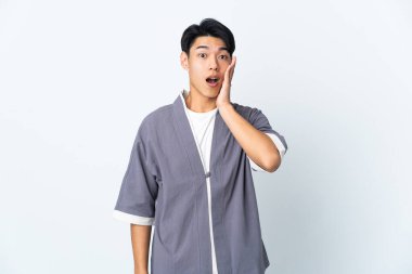 Beyaz arka planda mahsur kalmış genç bir Çinli şaşırmış ve şok olmuş bir yüz ifadesi var.