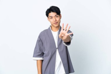 Beyaz arka planda izole edilmiş genç bir Çinli mutlu ve parmaklarıyla dört kişi sayıyor.