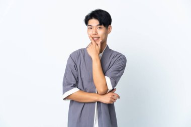 Genç Çinli adam beyaz arka planda izole edilmiş mutlu ve gülümsüyor.