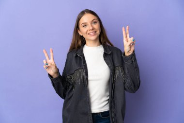 Mor arka planda izole edilmiş genç Litvanyalı kadın iki eliyle zafer işareti gösteriyor.