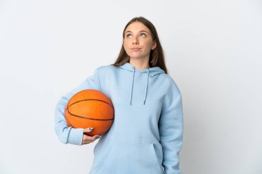 Basketbol oynayan Litvanyalı genç bir kadın beyaz arka planda izole edilmiş ve yukarı bakıyor.