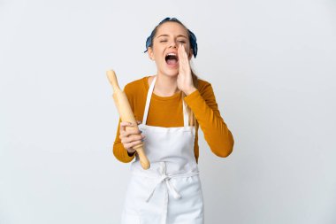 Genç Litvanyalı bir kadın elinde oklavayla beyaz arka planda izole edilmiş bağırıyor ve bir şey duyuruyor.