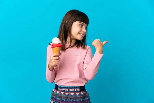 青い背景にアイスクリームを隔離し 製品を提示する側を指している小さな女の子 — ストック写真
