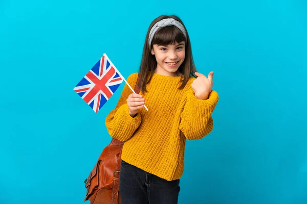 一个在蓝色背景下学习英语的小女孩举起了一个大拇指 — 图库照片