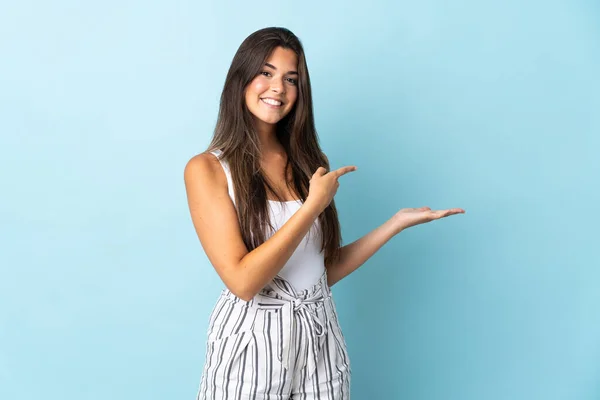 Jovem Brasileira Isolada Fundo Azul Segurando Espaço Imaginário Palma Mão — Fotografia de Stock