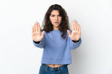 Beyaz arka planda izole edilmiş genç Rus kız dur hareketi yapıyor ve hayal kırıklığına uğruyor.