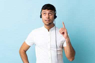 Kolombiyalı tele-pazarlamacı izole bir arka plan üzerinde çalışan bir adam bir fikri işaret ederek...