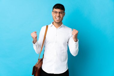 Kolombiyalı genç adam mavi arka planda tek başına zaferi kutluyor.