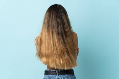 Genç beyaz kadın arka planda mavi arka planda izole edilmiş.