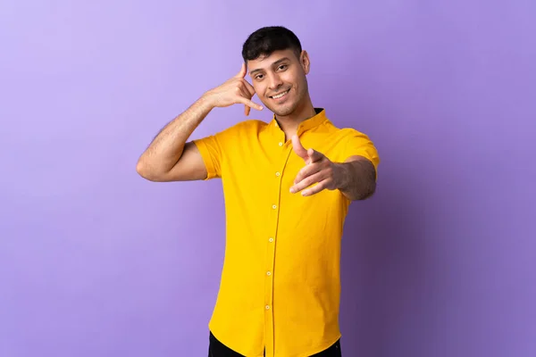 Young Colombian Man Isolated Purple Background Making Phone Gesture Pointing — Stock Photo, Image