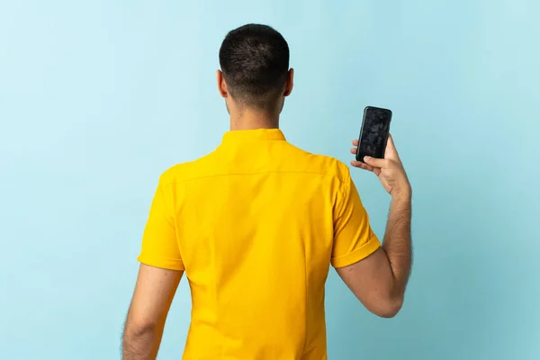 Jeune Homme Colombien Utilisant Téléphone Mobile Isolé Fond Bleu Position — Photo