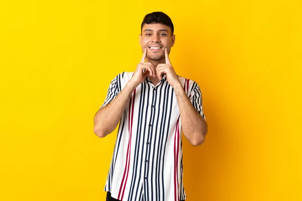 Junger Kolumbianischer Mann Isoliert Auf Gelbem Hintergrund Lächelt Mit Einem — Stockfoto