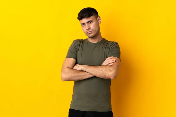 不幸な表情で黄色の背景に隔離された若いコロンビア人男性 — ストック写真