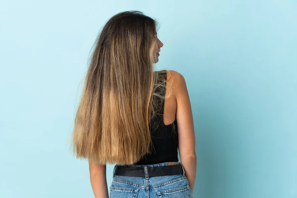 Jonge Blanke Vrouw Geïsoleerd Blauwe Achtergrond Achterste Positie Zoek Kant — Stockfoto