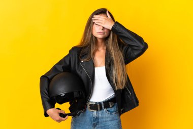 Sarı arka planda izole edilmiş motosiklet kaskı tutan kadın gözlerini elleriyle kapatıyor. Bir şey görmek istemiyorum.