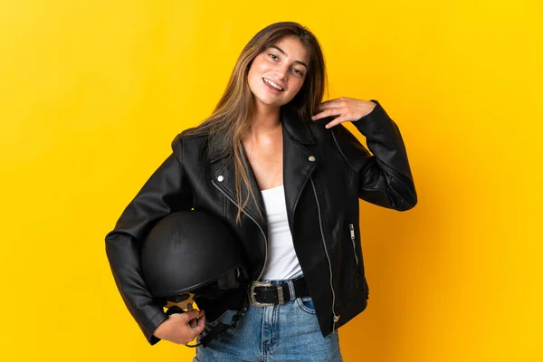 黄色の背景に隔離されたオートバイのヘルメットを持っている女性笑い — ストック写真