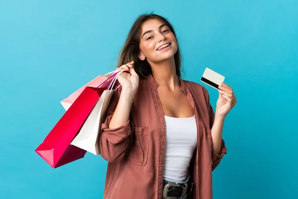 Junge Kaukasierin Isoliert Auf Blauem Hintergrund Mit Einkaufstaschen Und Kreditkarte — Stockfoto