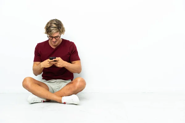 Молодий Англієць Сидить Підлозі Посилає Повідомлення Мобільним Телефоном — стокове фото