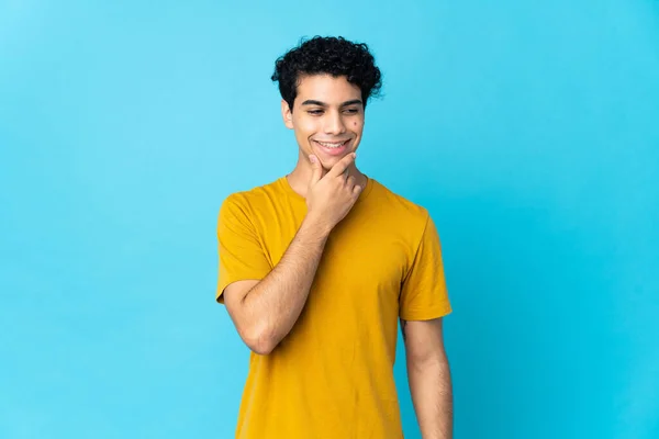 Jonge Venezolaanse Man Geïsoleerd Blauwe Achtergrond Kijken Naar Zijkant Glimlachen — Stockfoto