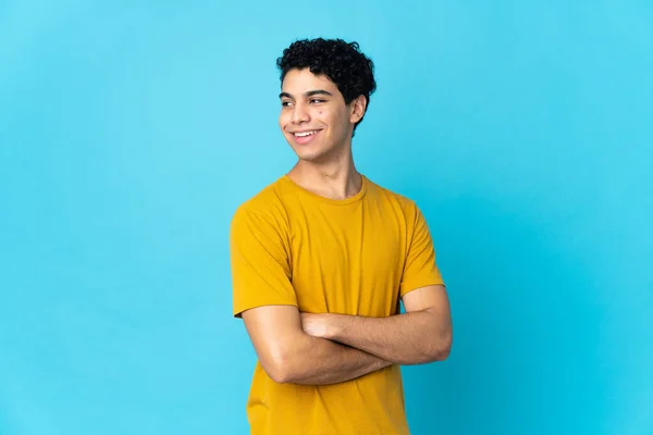 Mladý Venezuelský Muž Izolovaný Modrém Pozadí Zkříženýma Rukama Šťastný — Stock fotografie