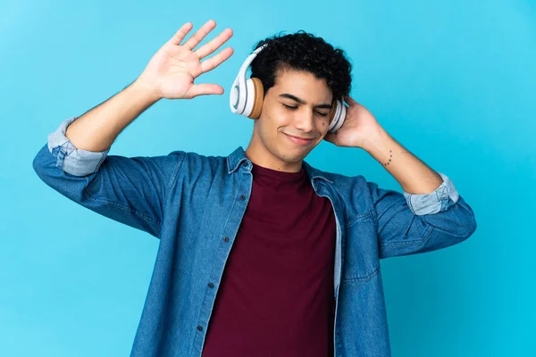 Νεαρός Βενεζουέλας Απομονωμένος Μπλε Φόντο Ακούγοντας Μουσική Και Χορεύοντας — Φωτογραφία Αρχείου