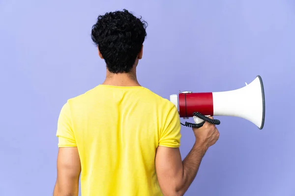 Jonge Venezolaanse Man Geïsoleerd Paarse Achtergrond Met Een Megafoon Rug — Stockfoto