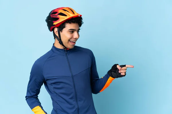 Hombre Ciclista Venezolano Aislado Sobre Fondo Azul Apuntando Con Dedo — Foto de Stock