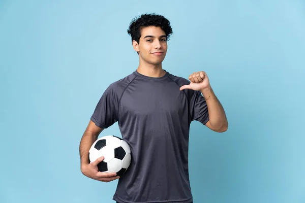 Jogador de futebol forte com bola de futebol e sorrindo em fundo branco  isolado