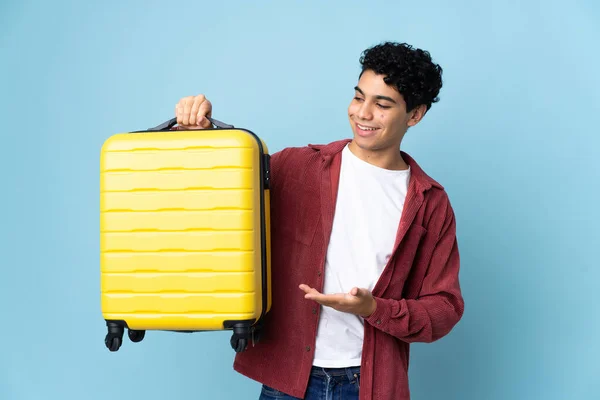 Jonge Venezolaanse Man Geïsoleerd Blauwe Achtergrond Vakantie Met Reiskoffer — Stockfoto