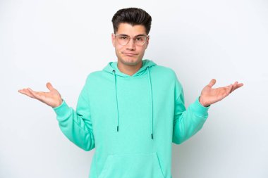 Beyaz fırında izole edilmiş genç, yakışıklı beyaz bir adam. Kuşkuları var ve ellerini kaldırıyor.