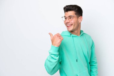 Beyaz fırında izole edilmiş yakışıklı beyaz adam bir ürün sunmak için yan tarafı işaret ediyor.