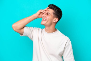 Genç, yakışıklı, beyaz bir adam, mavi bir fırında izole edilmiş, gülümsüyor.