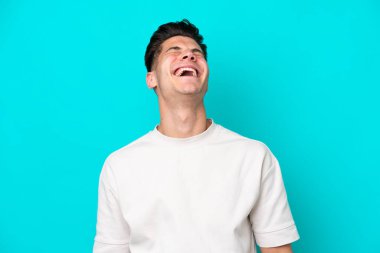 Genç, yakışıklı, beyaz bir adam mavi fırında yapayalnız gülüyor.