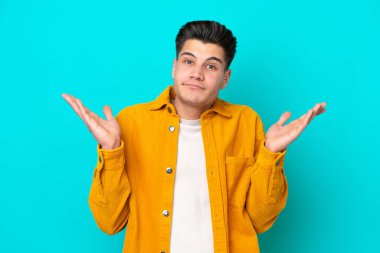 Genç, yakışıklı, beyaz bir adam, mavi fırında izole edilmiş, şüpheli hareketler yapıyor.