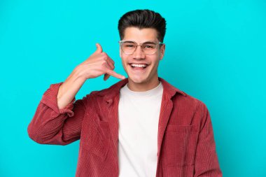 Mavi fırında gözlüklü ve telefon hareketleriyle izole edilmiş yakışıklı beyaz bir adam.