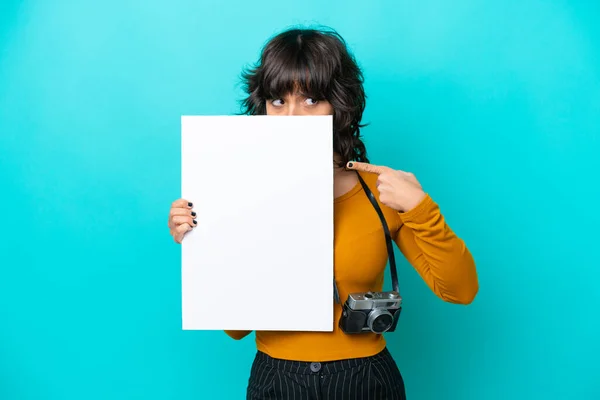 年轻的摄影师拉汀女士被隔离在蓝色背景下 她拿着一个空布告 藏在布告后面 — 图库照片