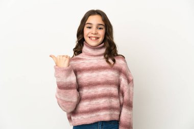 Beyaz arka planda izole edilmiş küçük beyaz kız bir ürünü sunmak için kenarı işaret ediyor.