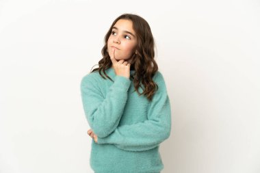 Beyaz arka planda izole edilmiş küçük beyaz kız yukarı bakarken şüpheleri var.