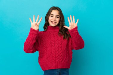 Mavi arka planda izole edilmiş küçük beyaz kız parmaklarıyla dokuzu sayıyor.