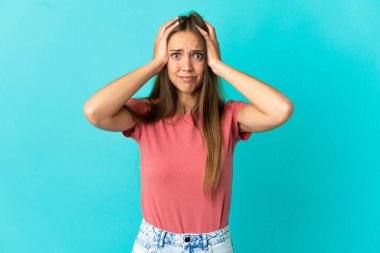 Soyutlanmış mavi arka planda genç bir kadın gergin hareketler yapıyor.