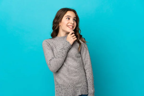 Kleines Kaukasisches Mädchen Auf Blauem Hintergrund Isoliert Und Lächelnd Aufblickend — Stockfoto