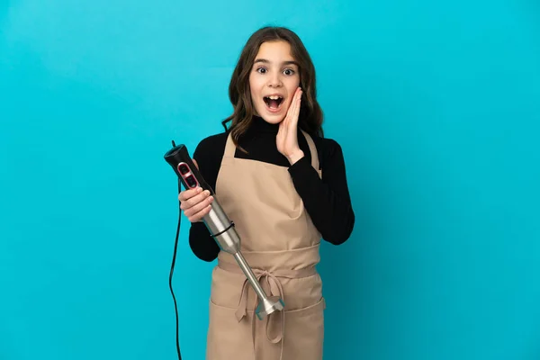 Menina Usando Liquidificador Mão Isolado Fundo Azul Com Surpresa Expressão — Fotografia de Stock