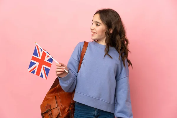 Menina Segurando Uma Bandeira Reino Unido Isolado Fundo Rosa Olhando — Fotografia de Stock