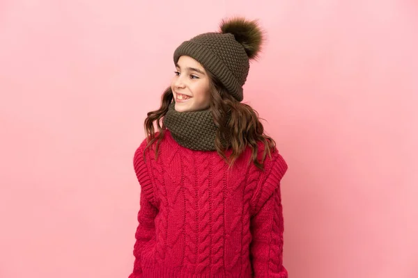 Liten Flicka Med Vinter Hatt Isolerad Rosa Bakgrund Tittar Sidan — Stockfoto