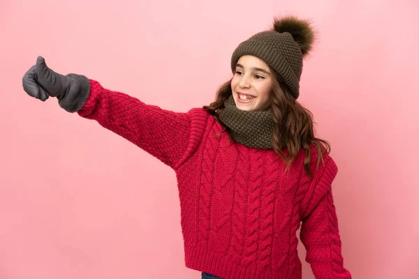 Liten Flicka Med Vinter Hatt Isolerad Rosa Bakgrund Ger Tummen — Stockfoto