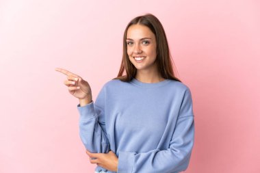 Soyutlanmış pembe arka planda genç bir kadın parmak gösteriyordu.