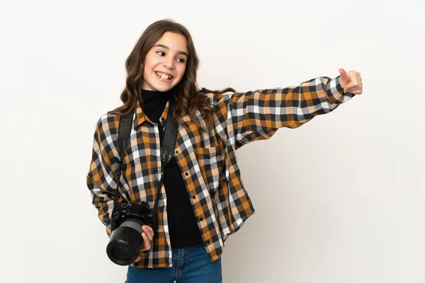 Little photographer girl isolated on background giving a thumbs up gesture